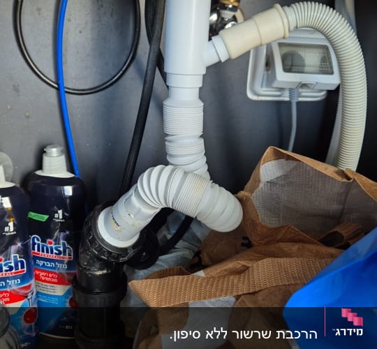כיור עם צנרת וכלים מתחת לכיור